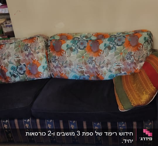 כריות צבעוניות על ספה כהה עם ריפוד פרחוני